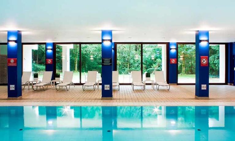 indoor pool with surrounding sunbeds at DoubleTree by Hilton Luxembourg.