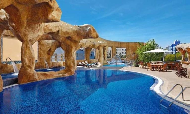 stunning outdoor pool surrounded by sun beds and seating area at Hilton Beirut Habtoor Grand.