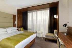 spacious king suite with TV, work desk, chair, and lounge area at DoubleTree by Hilton Zagreb.