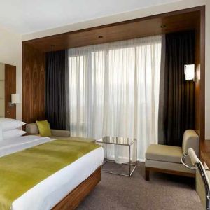 spacious king suite with TV, work desk, chair, and lounge area at DoubleTree by Hilton Zagreb.