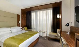 spacious king suite with TV, work desk, chair, and lounge area at DoubleTree by Hilton Zagreb.