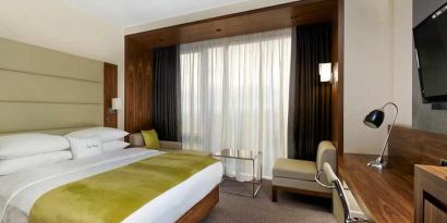 spacious king suite with TV, work desk, chair, and lounge area at DoubleTree by Hilton Zagreb.