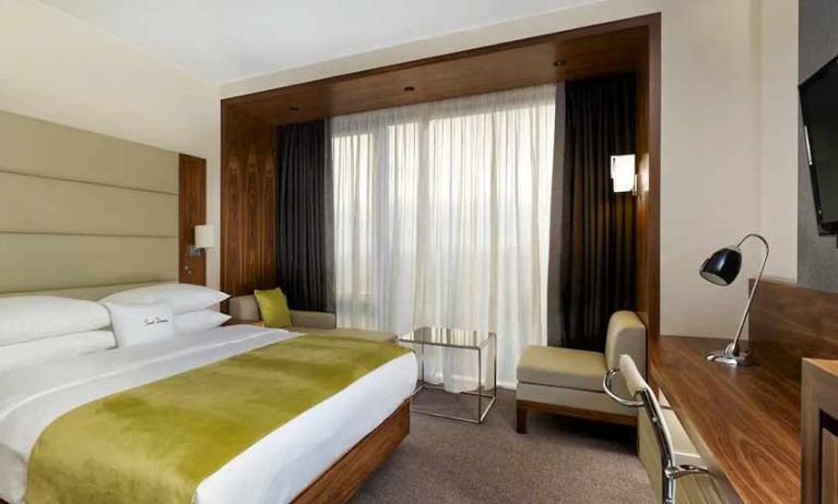 spacious king suite with TV, work desk, chair, and lounge area at DoubleTree by Hilton Zagreb.