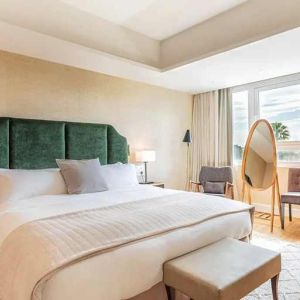 spacious king room with chair and desk and lots of natural light at Hilton Nicosia.