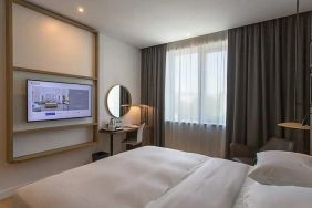 comfortable king suite with TV, work desk, and chair at Hilton Garden Inn Zagreb - Radnicka.