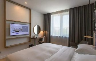 comfortable king suite with TV, work desk, and chair at Hilton Garden Inn Zagreb - Radnicka.