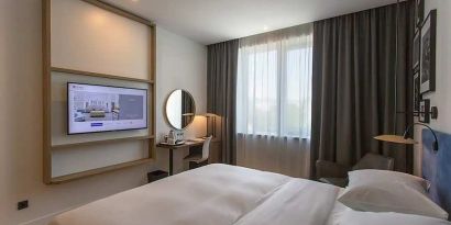 comfortable king suite with TV, work desk, and chair at Hilton Garden Inn Zagreb - Radnicka.