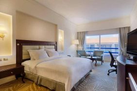 lovely king suite with TV, lounge area, work desk, and chair at Hilton Alexandria Green Plaza.