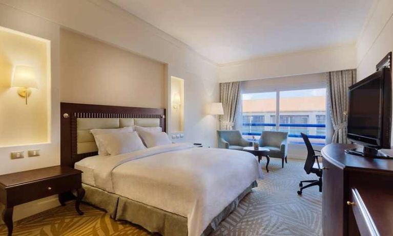 lovely king suite with TV, lounge area, work desk, and chair at Hilton Alexandria Green Plaza.