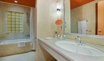 clean and spacious king bathroom with shower and bath combo at Hilton Alexandria Green Plaza.