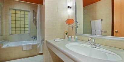 clean and spacious king bathroom with shower and bath combo at Hilton Alexandria Green Plaza.