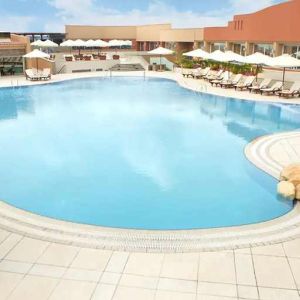 stunning outdoor pool with sunbeds and umbrellas at Hilton Alexandria Green Plaza.