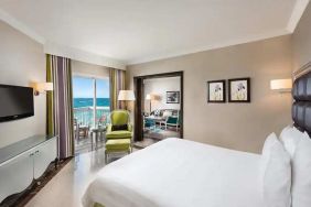 luxurious king room with TV, outdoor terrace, and sea views at Hilton Alexandria Corniche.