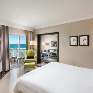 luxurious king room with TV, outdoor terrace, and sea views at Hilton Alexandria Corniche.