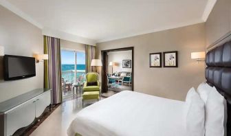 luxurious king room with TV, outdoor terrace, and sea views at Hilton Alexandria Corniche.