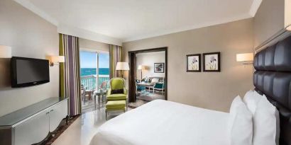 luxurious king room with TV, outdoor terrace, and sea views at Hilton Alexandria Corniche.