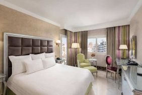 spacious king room with TV, desk, chair, and couch at Hilton Alexandria Corniche.