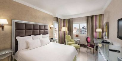 spacious king room with TV, desk, chair, and couch at Hilton Alexandria Corniche.