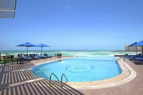 stunning outdoor pool with sunbeds and umbrellas at Hilton Alexandria Corniche.