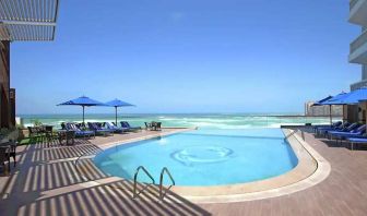 stunning outdoor pool with sunbeds and umbrellas at Hilton Alexandria Corniche.