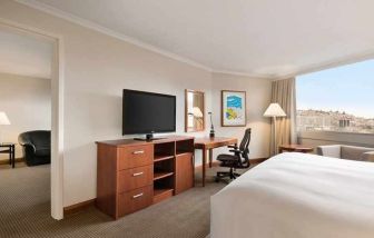 spacious king suite with TV, desk, chair, and couch at Hilton Colon Quito.