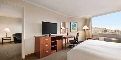 spacious king suite with TV, desk, chair, and couch at Hilton Colon Quito.