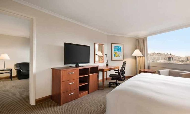 spacious king suite with TV, desk, chair, and couch at Hilton Colon Quito.