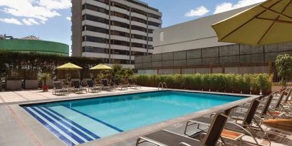 stunning outdoor pool with sunbeds and umbrellas at Hilton Colon Quito.