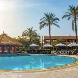 stunning outdoor pool with sunbeds and umbrellas at Hilton Cairo Heliopolis.