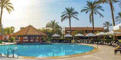 stunning outdoor pool with sunbeds and umbrellas at Hilton Cairo Heliopolis.