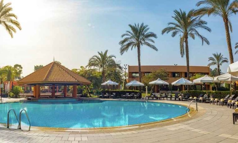 stunning outdoor pool with sunbeds and umbrellas at Hilton Cairo Heliopolis.