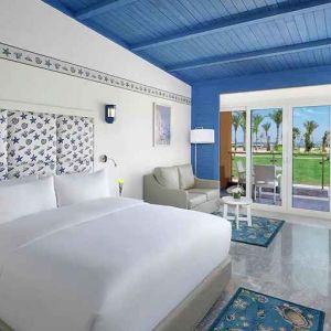 spacious king suite with desk, chair, couch, and outdoor terrace at Hilton Hurghada Plaza.