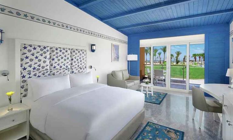 spacious king suite with desk, chair, couch, and outdoor terrace at Hilton Hurghada Plaza.