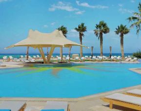 stunning outdoor pool with sunbeds and umbrellas at Hilton Hurghada Plaza.
