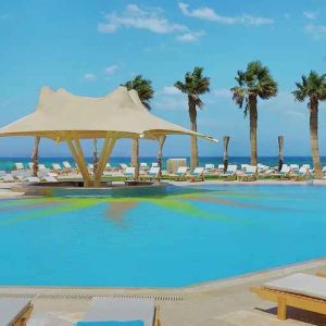 stunning outdoor pool with sunbeds and umbrellas at Hilton Hurghada Plaza.