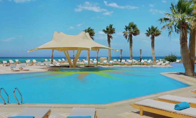 stunning outdoor pool with sunbeds and umbrellas at Hilton Hurghada Plaza.