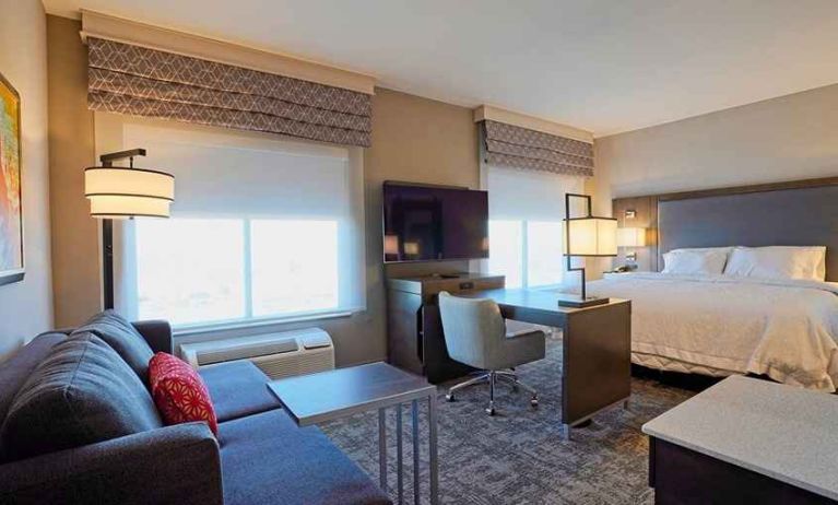 luxurious king suite with work desk and lounge area at Hampton Inn & Suites Lubbock University.