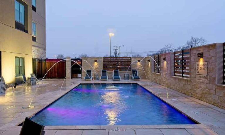 pretty outdoor pool with sun beds and seating area at Hampton Inn & Suites Lubbock University.