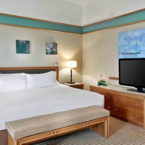 Queen room with chairs, desk and sliding doors at the Hilton Yaounde.