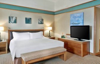 Queen room with chairs, desk and sliding doors at the Hilton Yaounde.