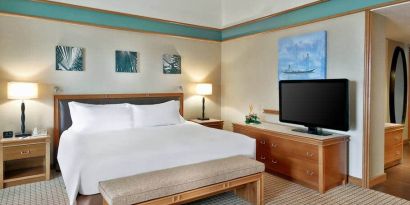 Queen room with chairs, desk and sliding doors at the Hilton Yaounde.