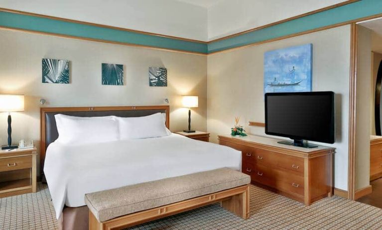 Queen room with chairs, desk and sliding doors at the Hilton Yaounde.