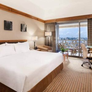 King suite with 1 king bed, desk,chair, tv and city view at the Hilton Yaounde.