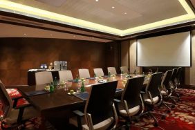 Sleek boardroom with large projection screen, seating for up to 12-15 people.