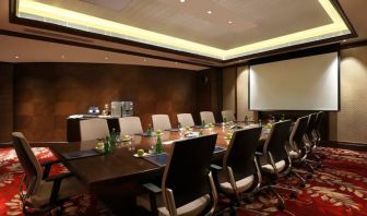 Sleek boardroom with large projection screen, seating for up to 12-15 people.