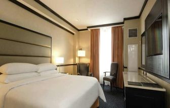 comfortable delux king room with TV and couches at Hilton Princess San Pedro Sula.
