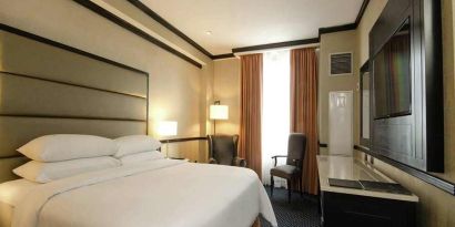 comfortable delux king room with TV and couches at Hilton Princess San Pedro Sula.