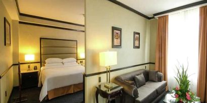 spacious king suite with comfortable lounge area at Hilton Princess San Pedro Sula.