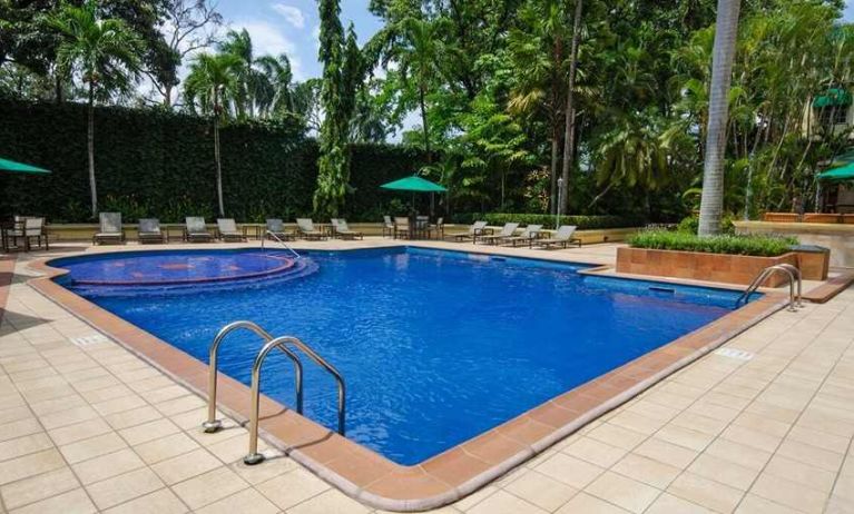 lovely outdoor pool with seating area and sun beds at Hilton Princess San Pedro Sula.