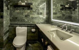 guest bathroom with basin, toilet, and shower at Hilton Garden Inn Guatemala City.